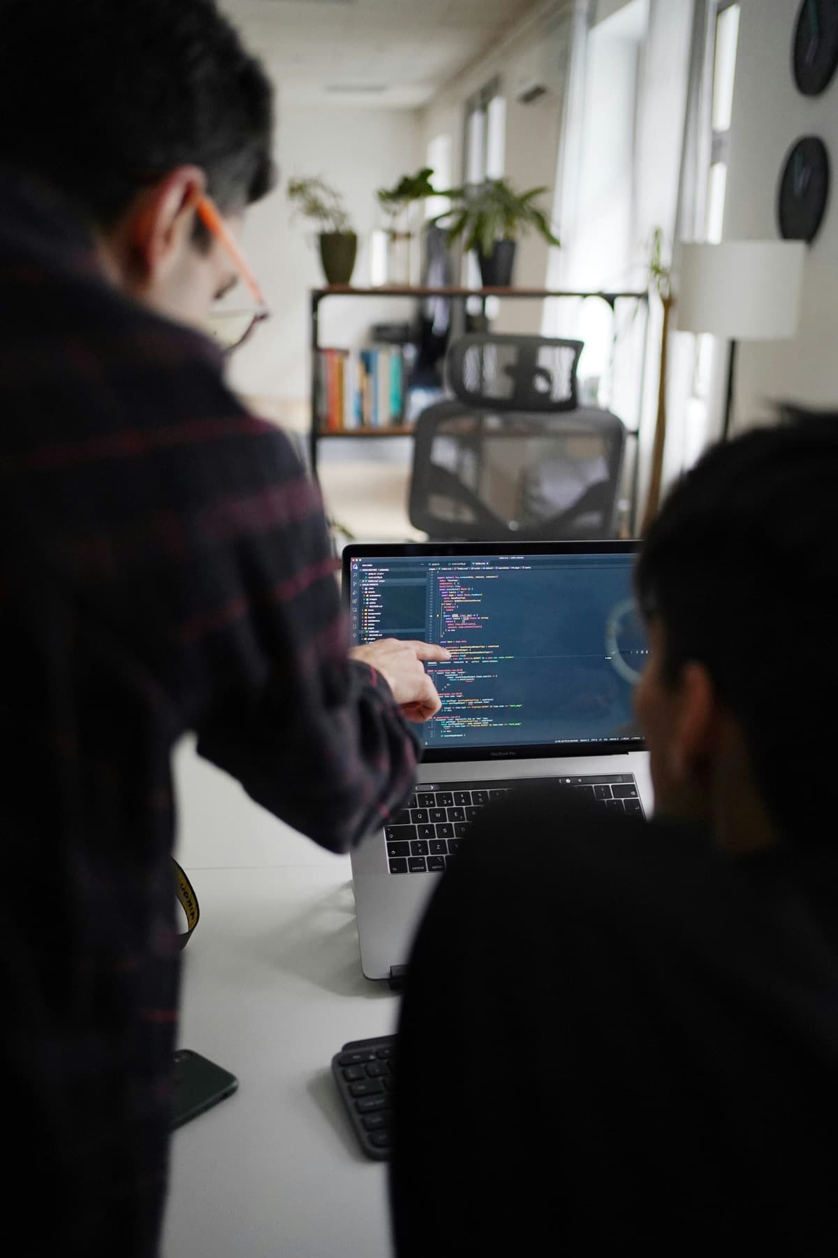 Developers collaborating around a laptop during a code review